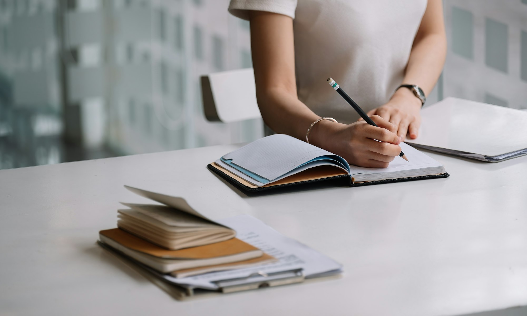 Close up of a woman writer hand writing in a notebook at home